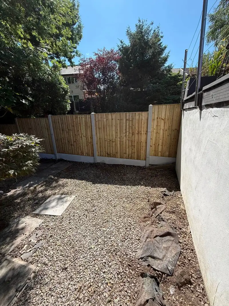 Panel fence with gravel boards along a gravelled side garden