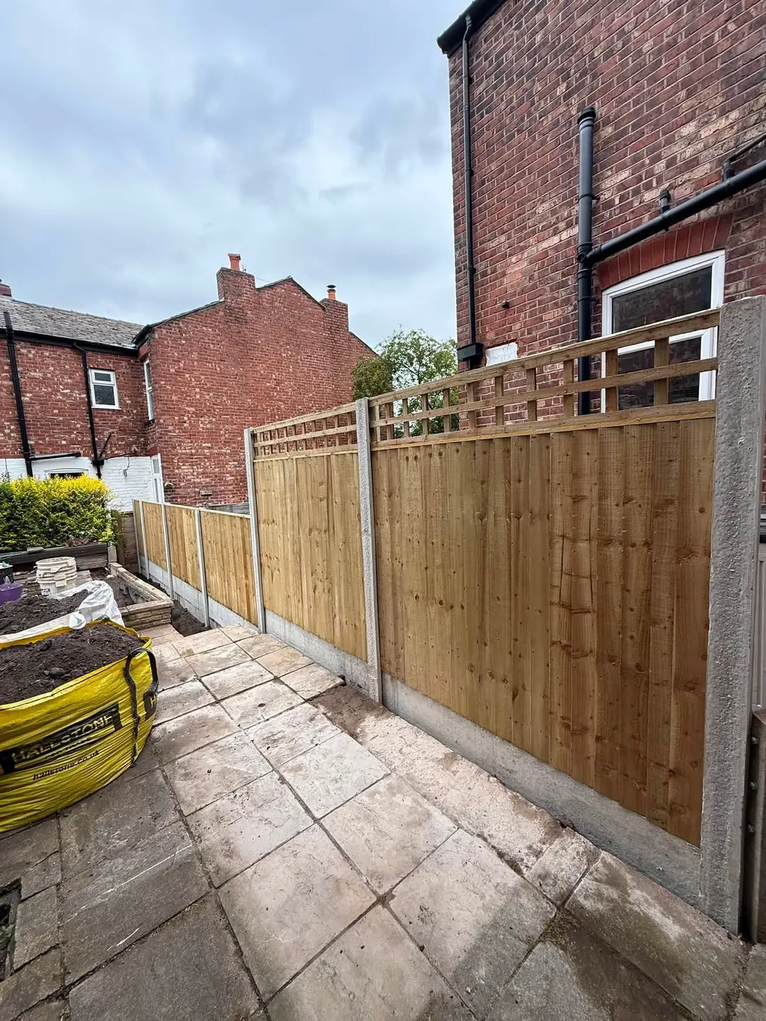 New closeboard fence with trellis topper, concrete posts and gravel boards in a terraced back garden