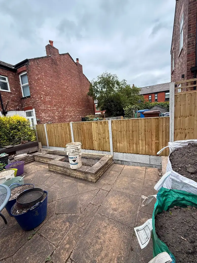 New panel fence around a paved garden with raised planters